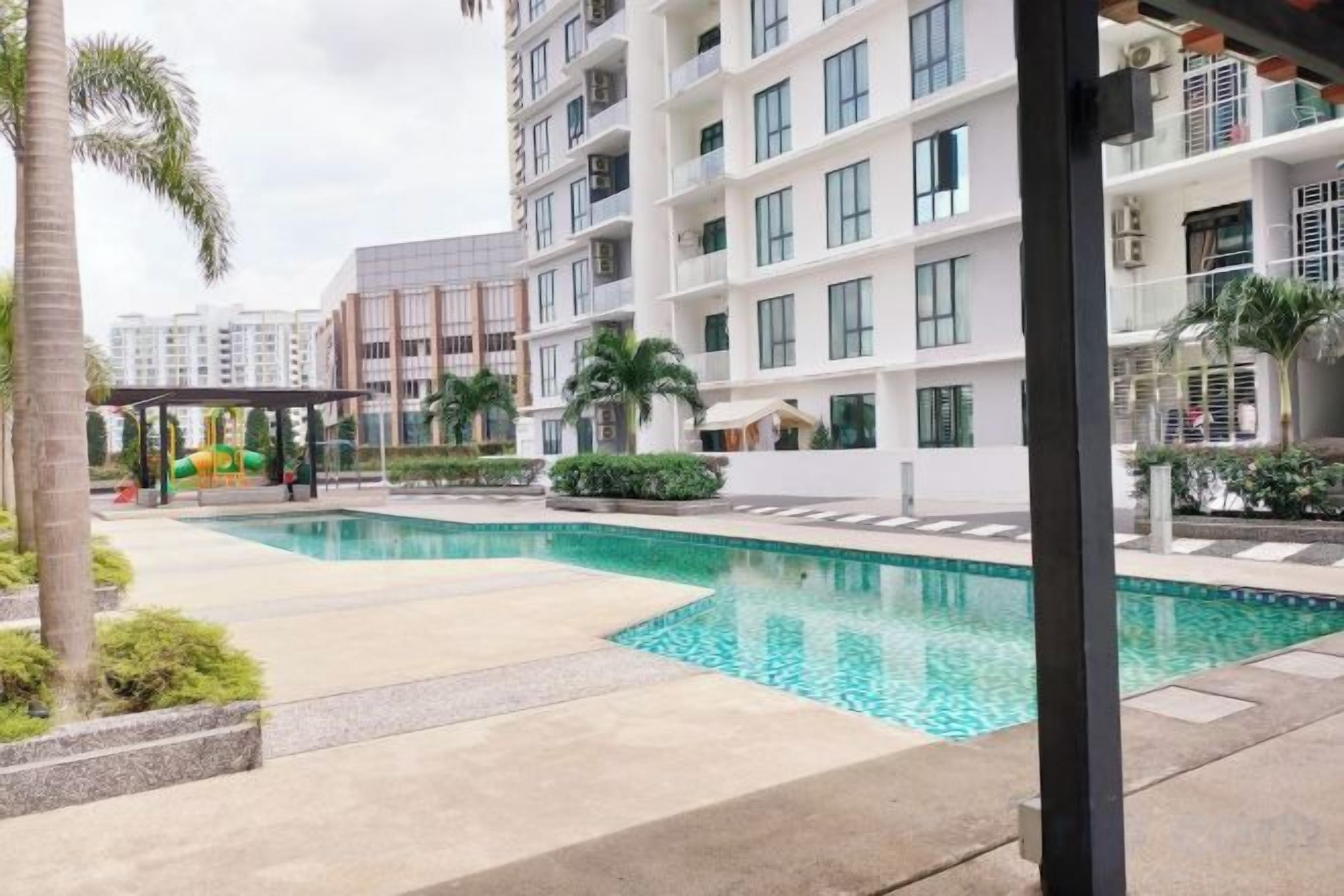 Un edificio residencial con piscina, zona cubierta y parque infantil.