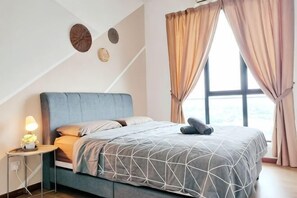 A bedroom with a bed, curtains, a nightstand with a lamp, and wall decor. - Delight Homestay The Platino (Tebrau)