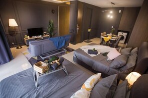 Une chambre d’hôtel moderne équipée d’un canapé, d’un lit, d’un coin repas et d’une télévision.