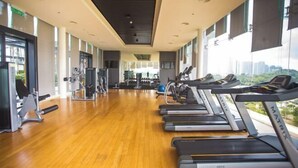 Egy edzőterem futópadokkal, súlyzókkal és fitneszlabdákkal felszerelve.