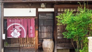 A traditional Japanese building with a wooden exterior, a large wooden gate, and a hanging banner with Japanese characters. - Ranjatai (Nara)