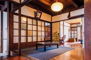 A traditional Japanese room with tatami flooring, a low wooden table, and a sliding door with shoji screens. - Ranjatai (Nara)