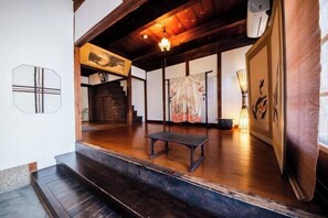 A traditional Japanese interior with wooden flooring, a staircase, and a small table. - Ranjatai (Nara)