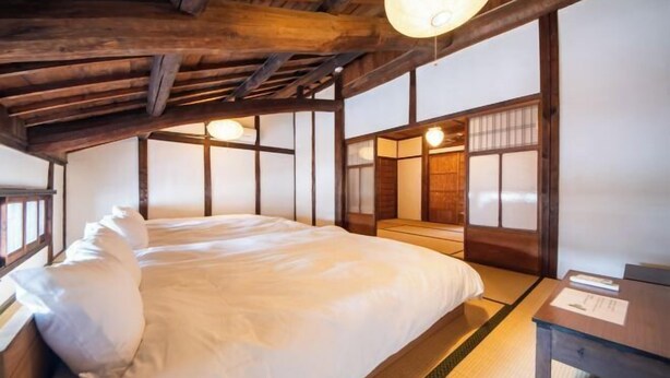 A traditional Japanese-style room with tatami flooring, a low wooden ceiling, and sliding doors. - Ranjatai (Nara)
