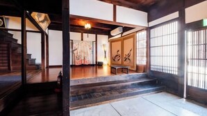 A traditional Japanese room with tatami flooring, a low wooden ceiling, and sliding doors. - Ranjatai (Nara)