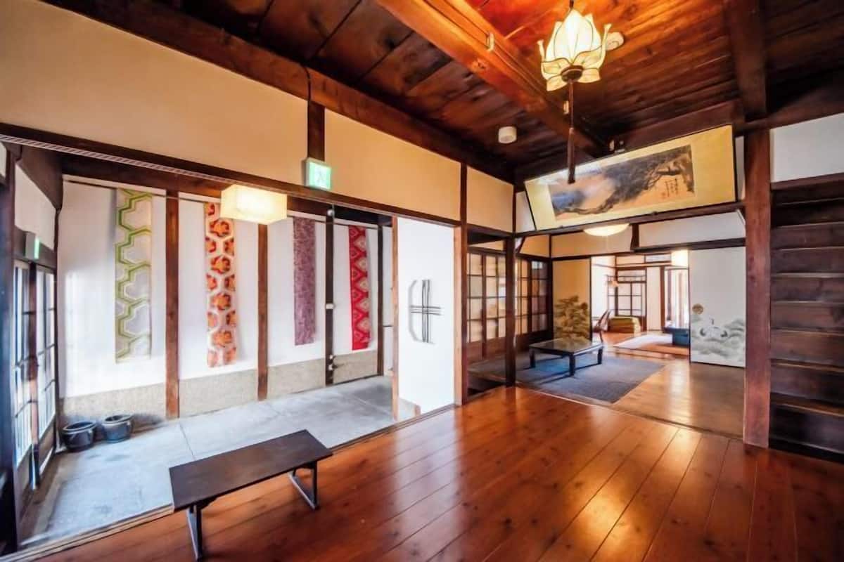 Un interior japonès tradicional amb bigues de fusta, tatami i portes corredisses.