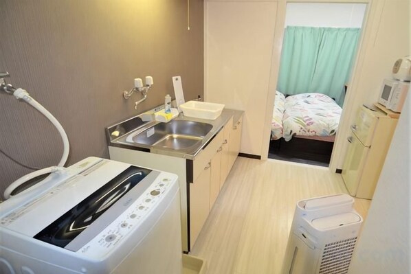 A compact hotel room with a kitchenette, a bed, and a small bathroom. - Comfort CUBE PHOENIX Miyazaki (Miyazaki)