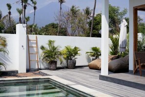 A pool area with a wooden ladder, potted plants, and outdoor seating. - 1BR Villa with Private Pool in Amed (Bali)