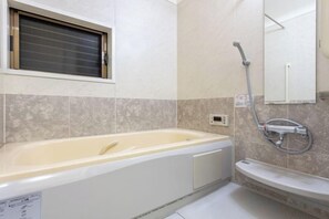 Ein Badezimmer mit einer Badewanne, einer Dusche und einem Waschbecken.