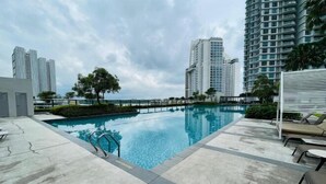 A swimming pool with a view of tall buildings and a cloudy sky. - NEW Serenity@Teega ResidenceL2 by UcomeHomestay (Iskandar Puteri)