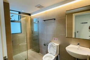 A modern bathroom with a glass-enclosed shower, a toilet, and a sink. - NEW Serenity@Teega ResidenceL2 by UcomeHomestay (Iskandar Puteri)