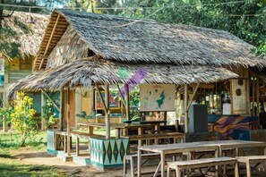 A rustic hut with a thatched roof, a wooden table, and a bench. - Bunga Jabe (Karimunjawa)
