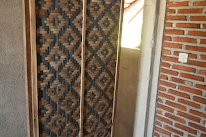 Un vano con un celosía de madera decorada y pared de ladrillo.