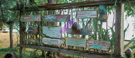 A wooden signpost with multiple directional signs in a natural setting.