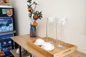 A wooden tray with two white teapots and two clear glass bottles on a table. - Galaxy Bui vien Street Home (Ho Chi Minh City)
