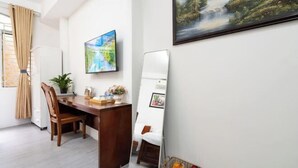 A modern room with a wooden desk, a large mirror, a painting, and a window with curtains. - Galaxy Bui vien Street Home (Ho Chi Minh City)
