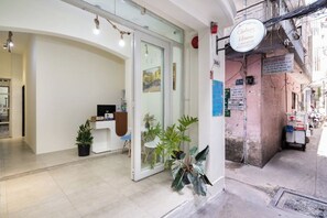 Una zona de recepción con un mostrador, sillas y plantas en macetas.