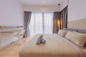A hotel room with a bed, a desk, and a chair. - Datum Jelatek Residence by FEEL HOME (Ampang)