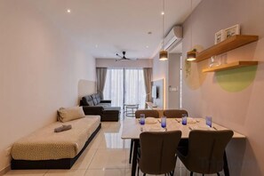 Una sala de estar moderna con un sofá, una mesa de comedor con sillas y un ventilador de techo.