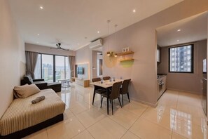 Una sala de estar moderna con sofá, mesa de comedor, sillas y un amplio ventanal.