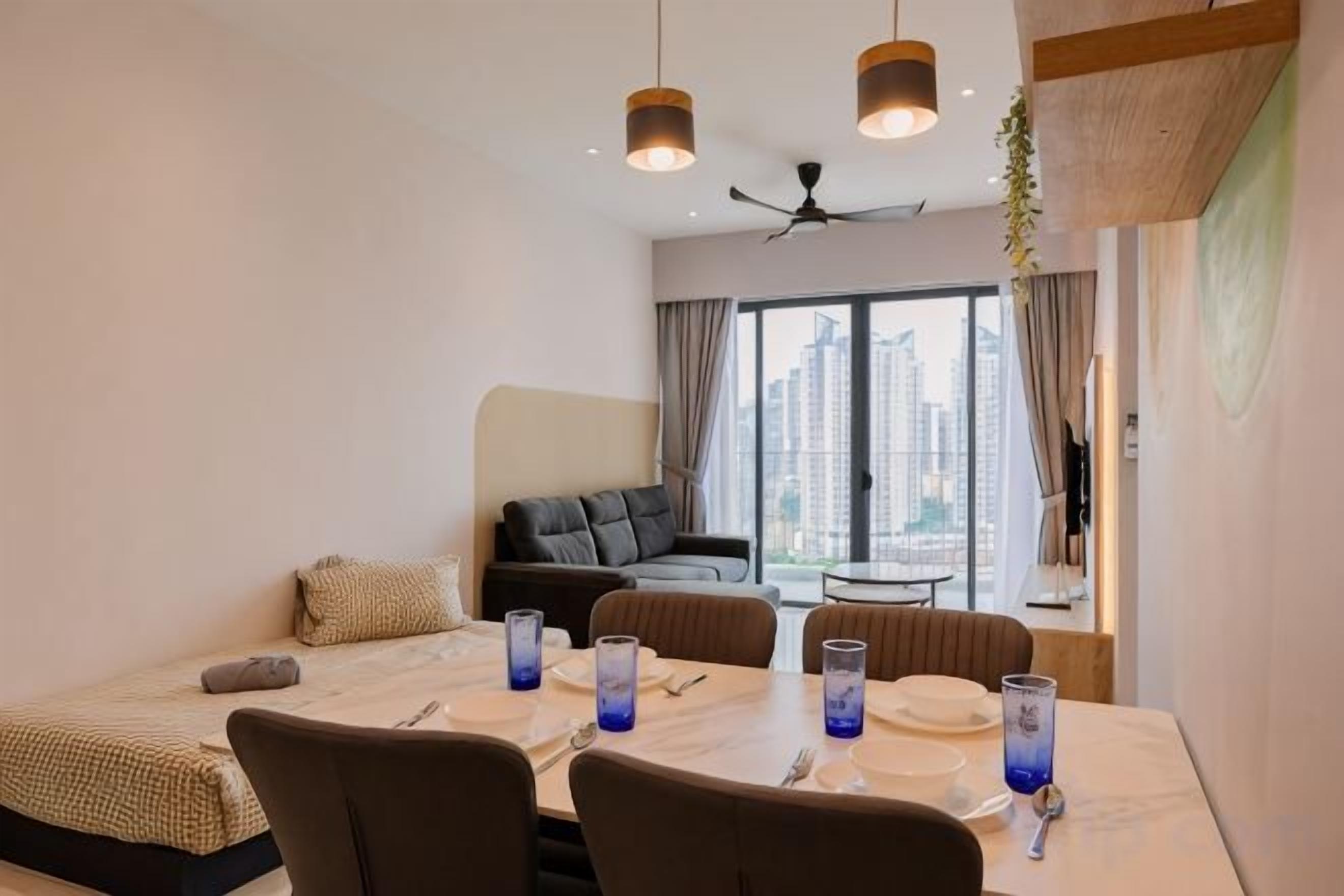 Une chambre d’hôtel avec un coin repas, un canapé et une vue sur la ville.