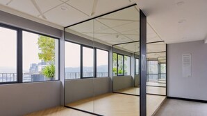 A spacious room with large windows, a wooden floor, and a glass partition. - Datum Jelatek Residence by FEEL HOME (Ampang)