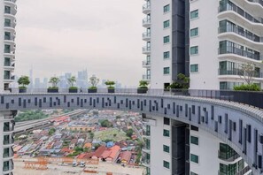 Un edificio de varios pisos con balcones, un puente y vistas a un paisaje urbano.