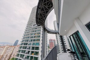Un edificio moderno con un elemento arquitectónico curvo, amplias ventanas y vistas de edificios altos circundantes.