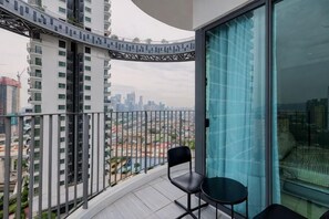 A balcony with a view of a cityscape, a chair, and a table. - Datum Jelatek Residence by FEEL HOME (Ampang)