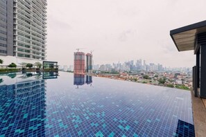 A rooftop swimming pool with a cityscape view, a high-rise building, and a construction site. - Datum Jelatek Residence by FEEL HOME (Ampang)