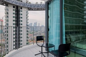 A balcony with a view of a cityscape, a glass door, and two chairs. - Datum Jelatek Residence by FEEL HOME (Ampang)