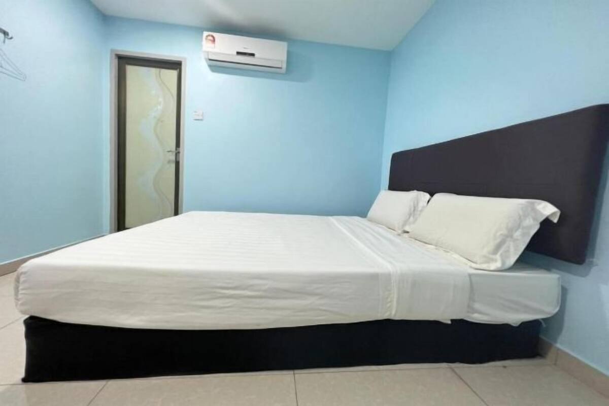 Ein Schlafzimmer mit einem Bett, einer Tür und einer Klimaanlage an der Wand.