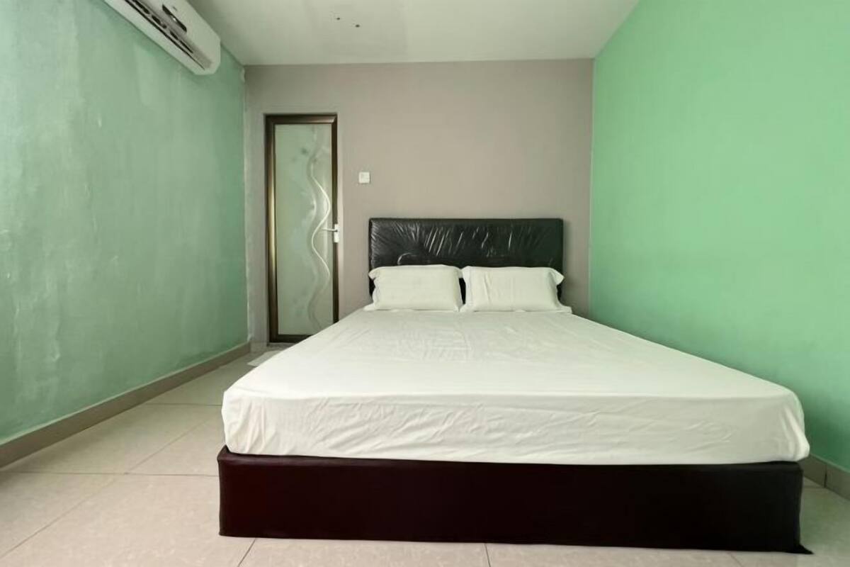 Ein Schlafzimmer mit einem Bett, einer Tür und einer Wand-Klimaanlage.