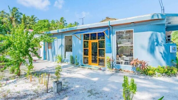 A small, single-story building with a blue exterior and a large glass door. - Evelyaa Guest House (Fulidhoo)