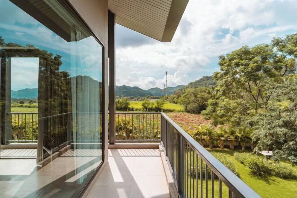 A balcony with a view of a lush landscape and mountains.