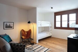 A room with a bunk bed, a sofa, a chair, a lamp, and a window. - Luxescape-No 2306-Traumaussicht-Ski & Wandergebiet-Paragleiten-Langlauf-Parkplatz (Treffen bei Villach)
