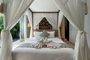 A bed with a canopy, pillows, and a decorative swan arrangement. - vila deh simba at seminyak aramanis (Bali)