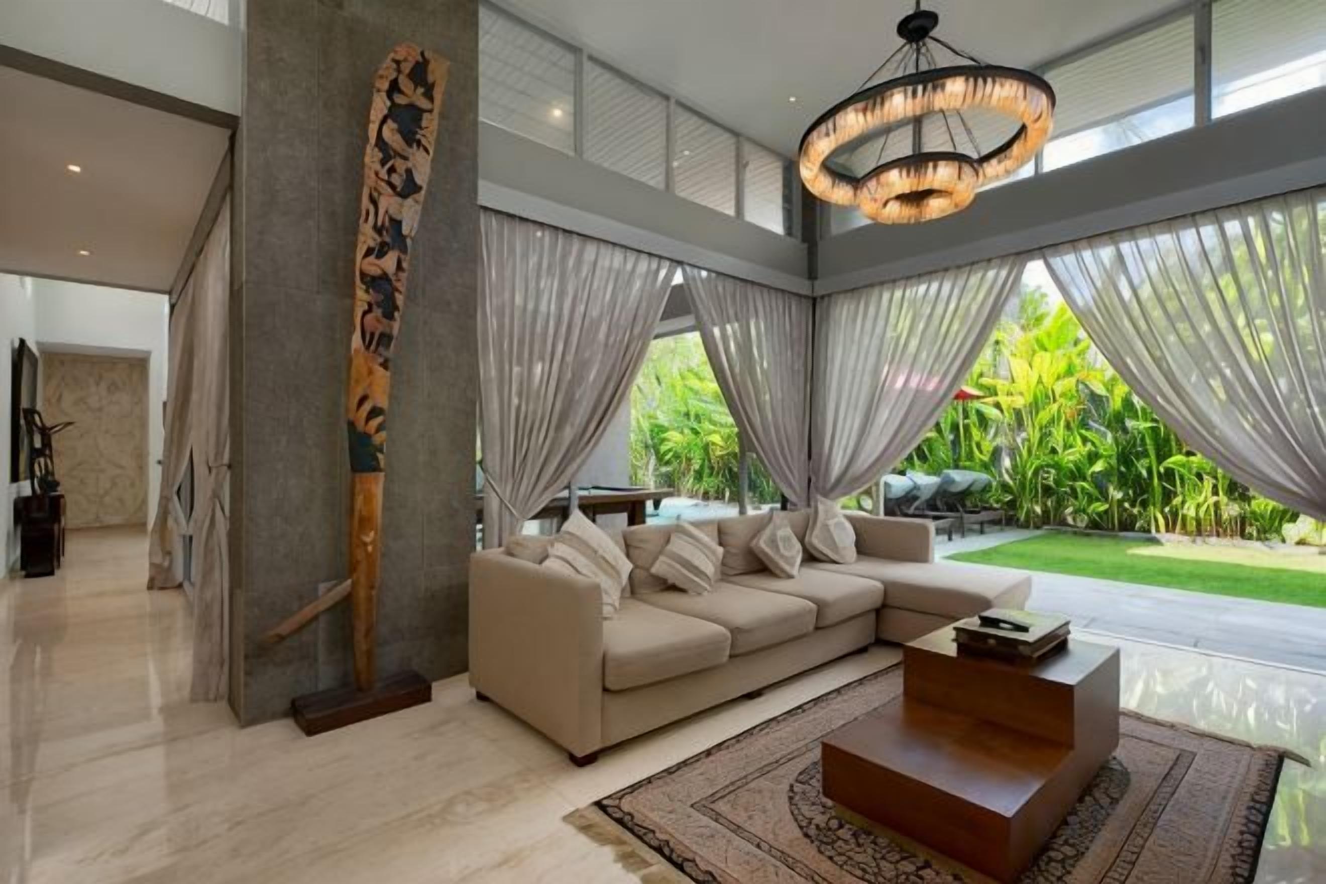 A modern living room with a sectional sofa, a coffee table, and a large abstract sculpture.