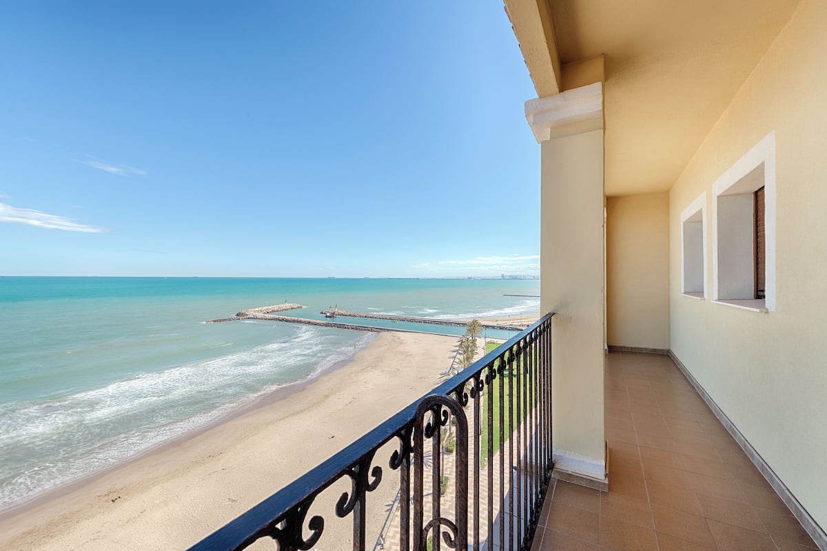 Varanda com vista para uma praia e oceano.