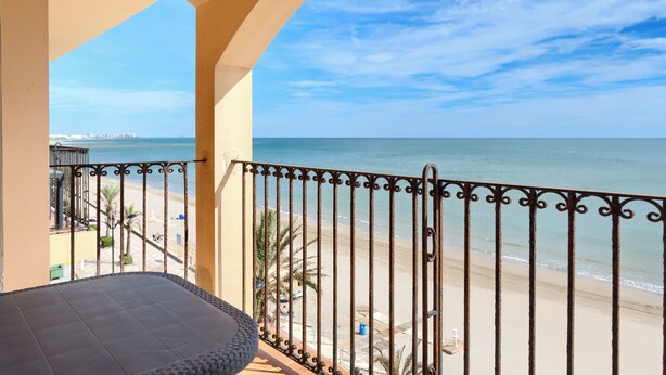 Un balcón con vista a la playa y al océano.