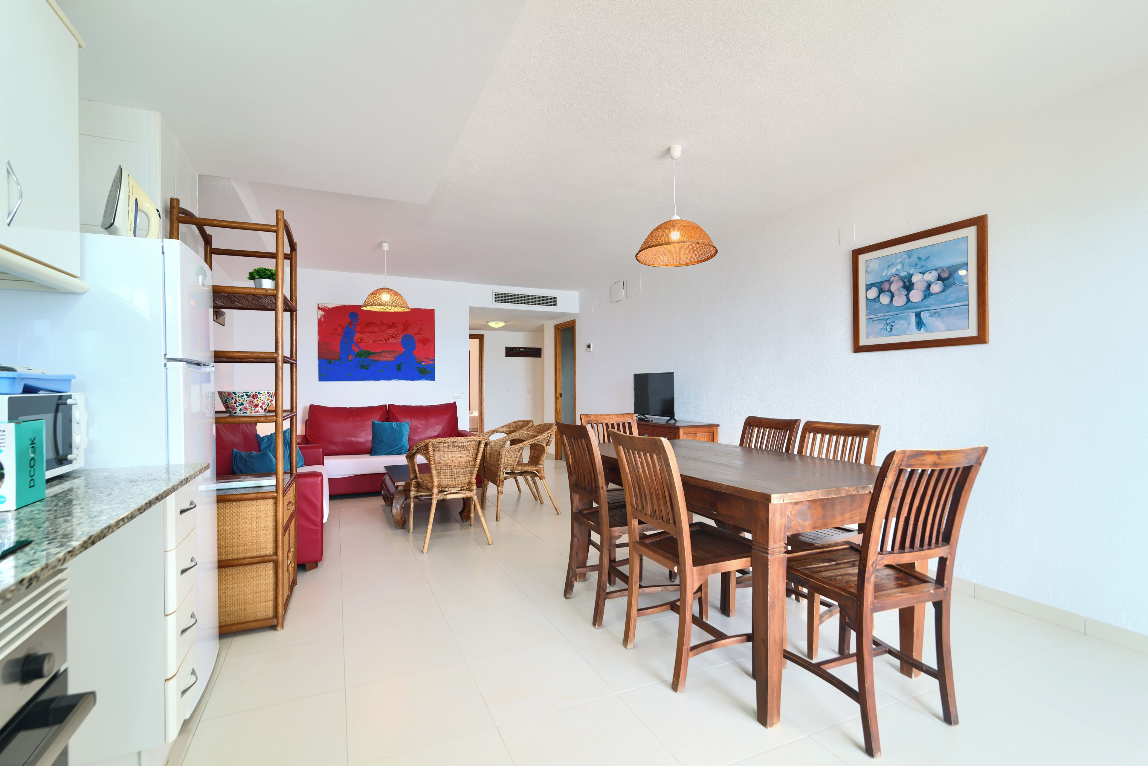 Un coin repas avec une table et des chaises en bois, un canapé et un téléviseur.