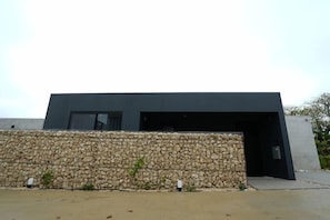Un bâtiment moderne doté d’un mur en pierre et d’un toit plat.
