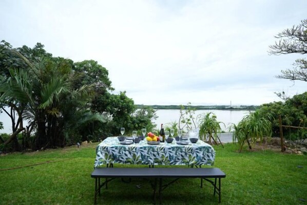 An outdoor dining table set up with a view of a body of water.