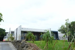 Un bâtiment moderne doté d’un toit plat, d’une façade en béton et d’une allée pavée.