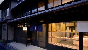 Un bâtiment traditionnel japonais avec une vitrine où sont exposés des produits de boulangerie.