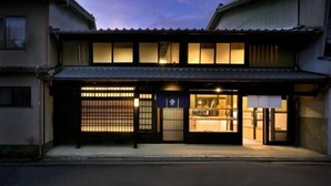 Un bâtiment japonais traditionnel doté d’une entrée couverte et d’un espace intérieur visible.