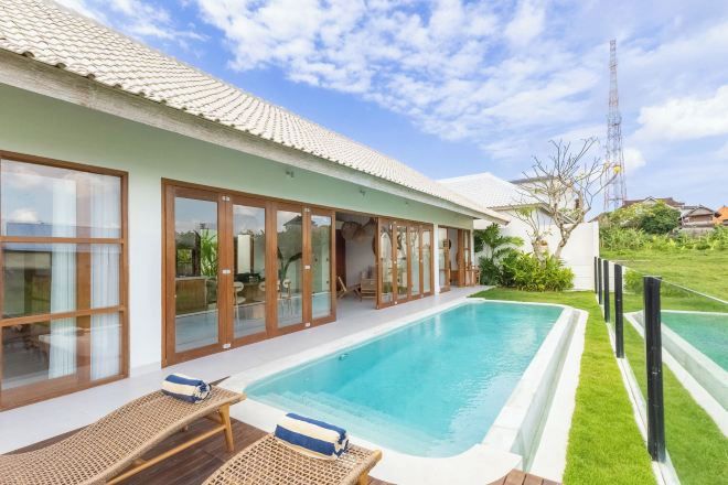 Una casa moderna con piscina, ventanas amplias y jardín.