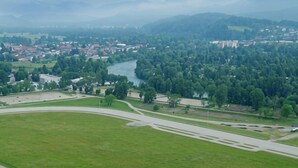 A green landscape with a river, buildings, and a road. - E&E Apartments Free Parking / Sports Arena LJ (Bezigrad District)