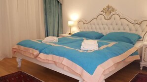A neatly made bed with a blue and peach bedspread, a white headboard, and a bedside lamp. - E&E Apartments Free Parking / Sports Arena LJ (Bezigrad District)