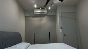 A bedroom with a bed, a wardrobe, an air conditioning unit, and a door. - Datum Jelatek Superb Suite KL By LH (Ampang)